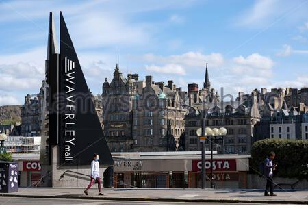 Leere Princes Street während der Coronavirus Covid-19 Epidemie, Fußgänger trägt eine Gesichtsmaske, als sie Waverley Mall, Edinburgh passieren Stockfoto