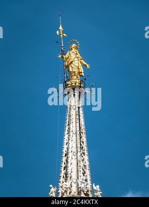 Madonnina auf dem Mailänder Dom in der Höhe von 108.5 m in Mailand, Italien. Goldene Statue der Madonna Nahaufnahme auf dem blauen Himmel Hintergrund. Berühmte Milan Cat Stockfoto