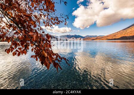 Schöner See Chuzenji (Nikko, Japan) mit Bergen, die sich an einem sonnigen Tag Ende Oktober im Wasser spiegeln. Stockfoto