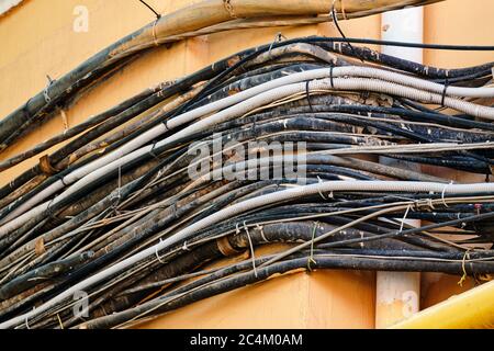 Zahlreiche elektrische Leitungen an der Fassade des Gebäudes. Stockfoto