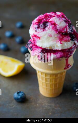 Zitrone gefrorener Joghurt mit Heidelbeersauce Stockfoto