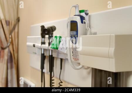 Nahaufnahme von medizinischen Instrumenten an einer Wand, Digitalthermometer, Otoskop, Ophthalmoskop Stockfoto