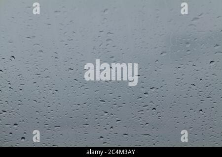 Nahaufnahme von Wassertropfen auf einer grauen Glasoberfläche Stockfoto