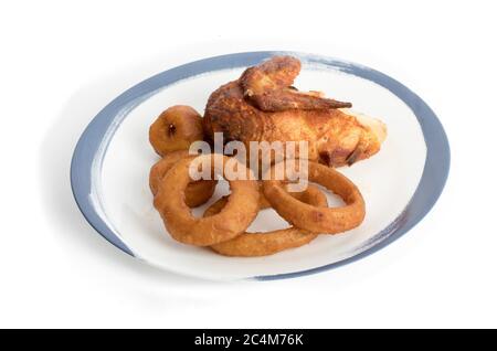 Hähnchen und Zwiebelringe auf einem blauen Teller auf Weiß isoliert braten Stockfoto