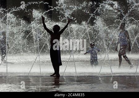 Kinder spielen in der Sommerhitze im Springbrunnen Stockfoto