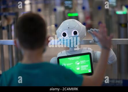 Athen. Juni 2020. Das Foto vom 26. Juni 2020 zeigt einen Jungen, der am internationalen Flughafen Athen in Athen, Griechenland, einen Pepper-Roboter bewob. DAZU: 'Feature: Athens int'l Airport rekrutiert Roboter, um Reisende über COVID-19-Maßnahmen zu informieren' Credit: Marios Lolos/Xinhua/Alamy Live News Stockfoto