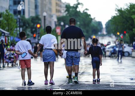 Washington, Usa. Juni 2020. Eine Frau, ein Mann und zwei Kinder halten sich am Samstag, den 27. Juni 2020 in Washington, DC, an der Black Lives Matter Plaza die Hände. Proteste, Demonstrationen und Versammlungen haben täglich seit dem Tod von George Floyd in Minneapolis, MN, stattgefunden. Foto von Leigh Vogel/UPI Kredit: UPI/Alamy Live News Stockfoto