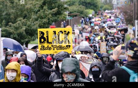 Stille Demonstranten marschieren im Regen durch die Viertel von Seattle und machen auf die Black Lives Matter Bewegung und die Brutalität der Polizei aufmerksam Stockfoto