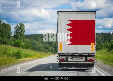 Ein LKW mit der Nationalflagge von Bahrain, die auf der Hintertür abgebildet ist, transportiert Güter in ein anderes Land entlang der Autobahn. Konzept von Export-Import,tran Stockfoto