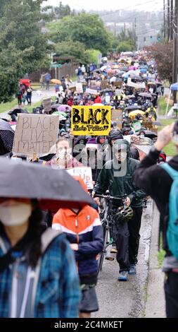 Stille Demonstranten marschieren im Regen durch die Viertel von Seattle und machen auf die Black Lives Matter Bewegung und die Brutalität der Polizei aufmerksam Stockfoto