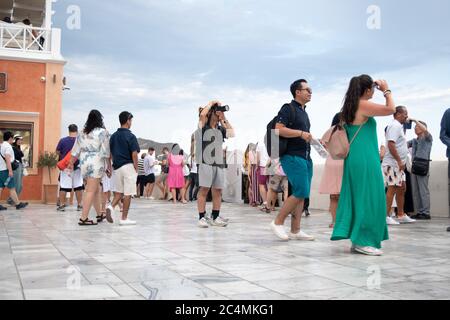 SANTORINI, GRIECHENLAND - JULI 18 2019: Wunderschönes Dorf Oia, überfüllt mit Touristen während des Tages, Santorini Insel, Griechenland. Stockfoto