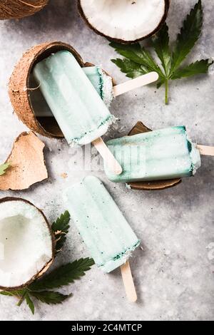 Eis-Eis-Eisdielen mit Kokosnussscheiben, Cannabis auf Betongrund. Stockfoto