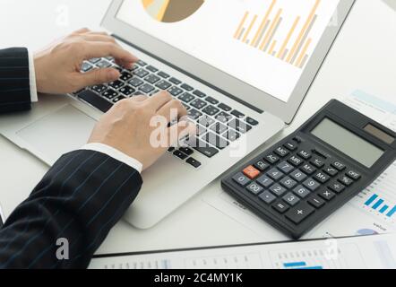 Geschäftsmann Analyse von Investmentdiagrammen und Geschäftsgraphen mit Laptop-Computer. Rechnungslegungskonzept. Draufsicht. . Stockfoto