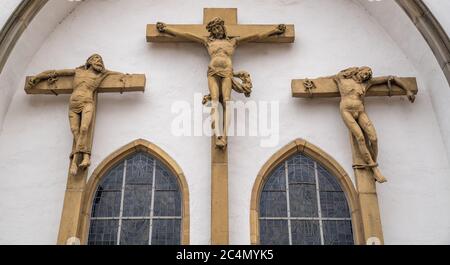 Niedrige Winkelaufnahme von christlichen Statuen mit Christus am Kreuz in Osnabrück, Deutschland Stockfoto