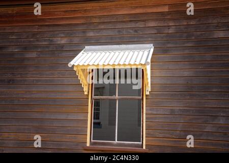Altmodische Metallfenster Markise auf der Seite eines Holzhauses Stockfoto