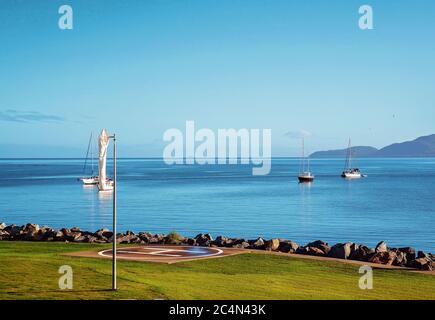 Yachten ankerten vor der Küste in der Nähe eines Hubschrauberlandeplatzes an einem schönen klaren, ruhigen Tag auf dem Meer Stockfoto