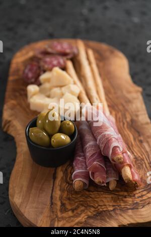 Italienische Snacks auf Olivenholzplatte Stockfoto