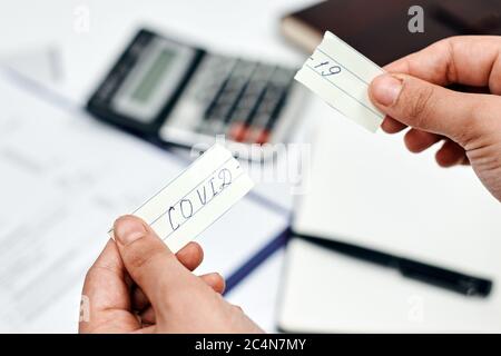 Wort 'Covid-19' auf zerrissenen Zettel über A geschrieben Rechner und Dokumente Stockfoto
