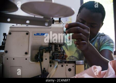 Politische Flüchtlinge und afrikanische Einwanderer arbeiten an der Schneiderei der gemeinnützigen Vereinigung im Süden Italiens, Neapel. Stockfoto