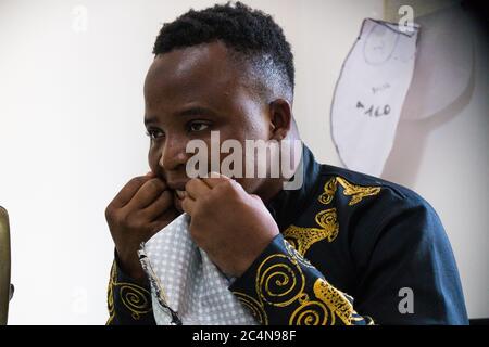 Politische Flüchtlinge und afrikanische Einwanderer arbeiten an der Schneiderei der gemeinnützigen Vereinigung im Süden Italiens, Neapel. Stockfoto