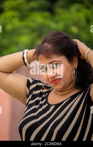 Schöne junge indische weibliche Modell trägt zurück und weiß Western-Kleid Stockfoto