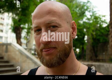 Der junge, gutaussehende, bärtige Mann zeigt seine Zunge vor die Kamera. Bild auf Lager. Stockfoto