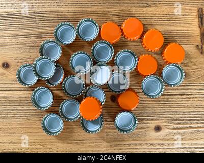 Viele orange Bier Deckel, Flasche Korken Tops auf einer hölzernen Textur Draufsicht horizontales Bild Stockfoto