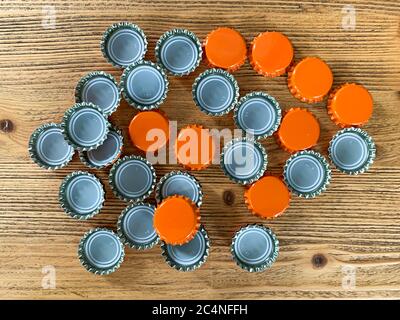 Viele orange Bier Deckel, Flasche Korken Tops auf einer hölzernen Textur Draufsicht horizontales Bild Stockfoto