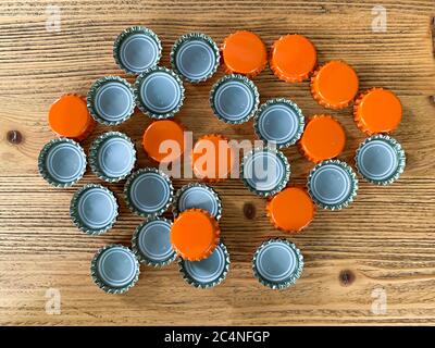 Viele orange Bier Deckel, Flasche Korken Tops auf einer hölzernen Textur Draufsicht horizontales Bild Stockfoto