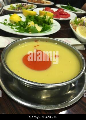 Traditionelle türkische gelbe Linsensuppe in Metallschüssel mit Salat und Gemüse Stockfoto