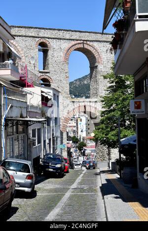 Kavala, Griechenland - 13. Juni 2019: Autos in einer engen Straße mit mittelalterlichem Aquädukt Kamares Stockfoto