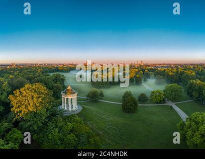 Herrliche Luftaufnahme über den Englischen Garten der bayerischen Landeshauptstadt München am frühen Morgen mit Nebel im grünen Park. Stockfoto