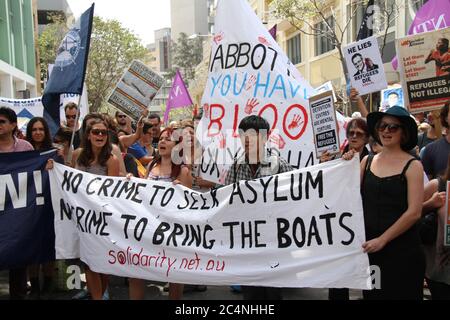 Demonstranten versammeln sich Ende des marsches vor dem Warringah-Büro von Tony Abbott in Manly. Sie halten Zeichen und singen zur Unterstützung der Flüchtlinge. Stockfoto