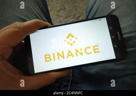 Mann hält Smartphone mit Binance Kryptowährungsbörse Logo Stockfoto