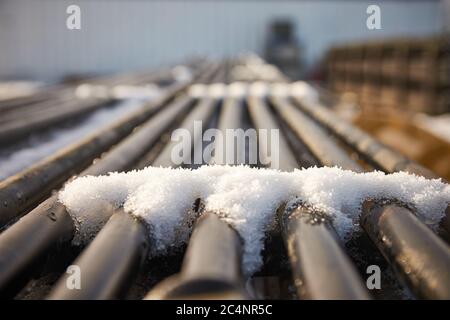 Selektive Fokusaufnahme von schmelzendem Schnee auf metallischen Rohren Stockfoto