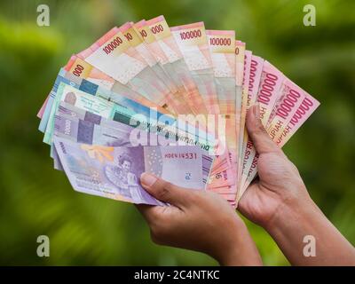 Indonesisches Geld in den Händen eines Mädchens. Stockfoto