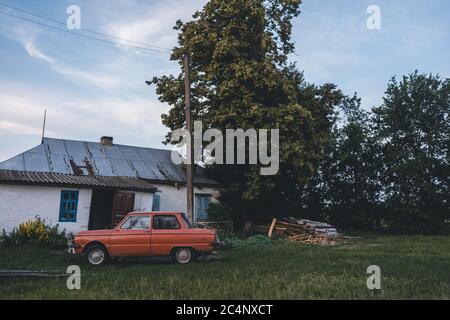 ukrainisches Dorf mit Haus und zaz Auto Stockfoto