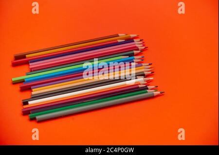 Farbstifte auf rot-orangem Hintergrund.Nahaufnahme. Stockfoto