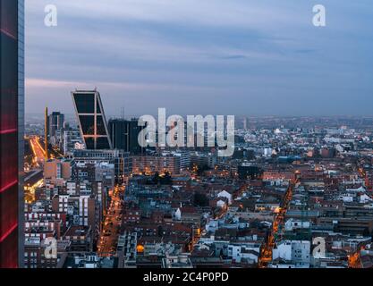 Blick von oben auf Castellana und Madrids Skyline bei Sonnenaufgang, mit den zwei schiefen modernen Büroblocks (Puerta de Europa) an der Plaza de Castilla Stockfoto