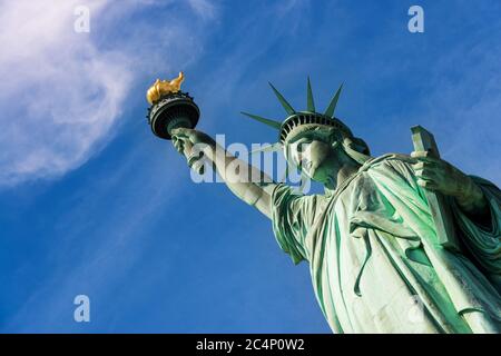 Nahaufnahme der Freiheitsstatue bei einem wolkigen blauen Himmel, New York City. Stockfoto