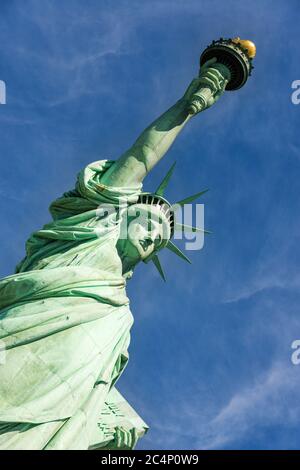 Nahaufnahme der Freiheitsstatue bei einem wolkigen blauen Himmel, New York City. Stockfoto