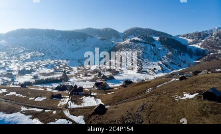 Felsige Berge voller Schnee und Dörfer im Tal Stockfoto