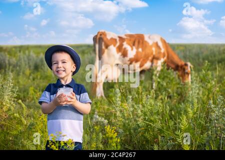 Kleiner Junge trinkt Joghurt im Freien Stockfoto