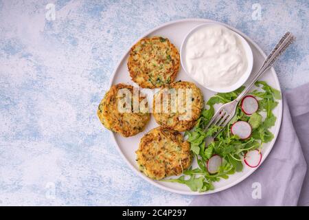 Zucchini-Krapfen mit Joghurt-Dip serviert. Stockfoto