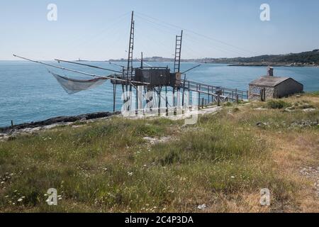 Typische traditionelle Fischerei Trabucco am Strand von Vieste. Im Hintergrund die Küste von Vieste auf Apulien in Italien, Europa Stockfoto