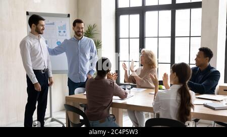 Lächelnde Führungskraft, die bei der Unternehmensbesprechung neue Angestellte vorstellt Stockfoto