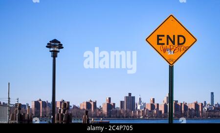 Williamsburg, Brooklyn, New York, Vereinigte Staaten von Amerika - ENDFAHRTENSCHILD im Hintergrund der Skyline von Manhattan über den East River. Stockfoto