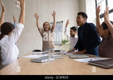 Begeistertes Team von Mitarbeitern, die Erfolge feiern, die Hände heben und schreien Stockfoto