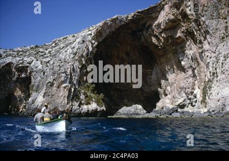 Urlauber in einem kleinen Boot besuchen die Blaue Grotte, Malta GC Stockfoto