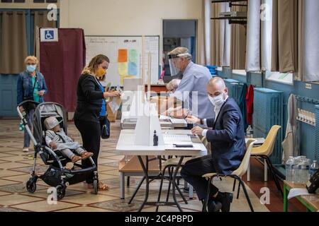 (200628) -- PARIS, 28. Juni 2020 (Xinhua) -- Menschen mit Schutzmasken bereiten sich auf die Wahl in einem Wahllokal während der zweiten Runde der Kommunalwahlen in Paris, Frankreich, am 28. Juni 2020 vor. Da sich die COVID-19-Epidemie in Frankreich immer besser entwickelt, werden am Sonntag rund 16.5 Millionen Wähler aufgerufen, im Rahmen eines strengen Gesundheitsprotokolls bei der zweiten Runde der Kommunalwahlen ihre Stimme zu geben. Die zweite Runde der Bürgermeisterwahlen war ursprünglich für März 22 geplant, aber die Verschlimmerung der Coronavirus-Ausbrüche und die Sperrung des Virus hatten die französische Regierung gezwungen, sie zu verschieben. (Foto von Aurelien Stockfoto